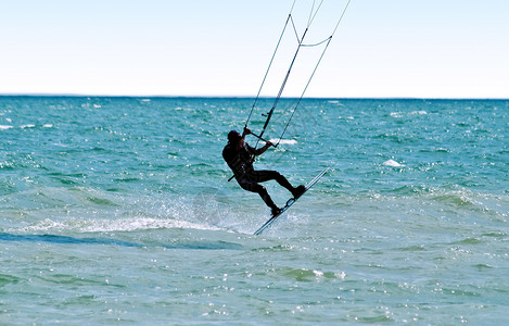 风筝冲浪者在海浪上的剪影图片