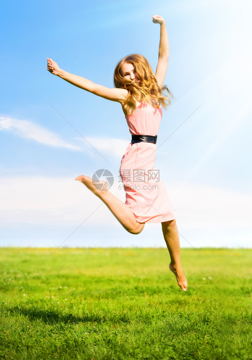 夏天领域背景的快乐跳跃女孩图片