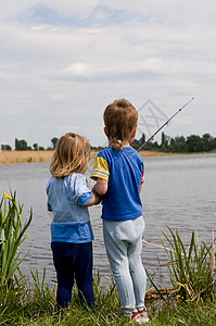 在湖边钓鱼的小男孩和女孩图片