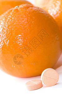 橙色背景下的维生素C丸图片
