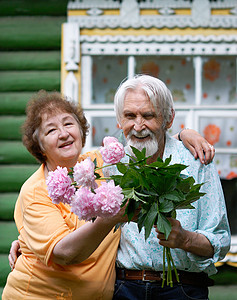 年长的丈夫和妻子手握着鲜花对房子图片