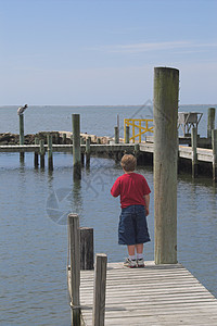 一个站在码头上的小男孩图片