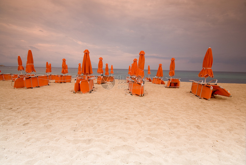 沙滩椅和沙滩上的雨伞图片