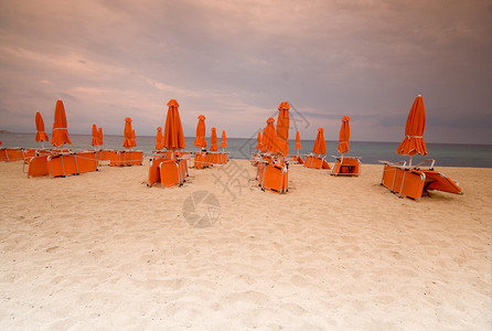 沙滩椅和沙滩上的雨伞图片