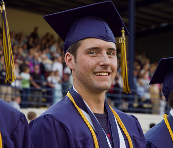 男高中毕业生在毕业阶段的镜头上微笑时图片