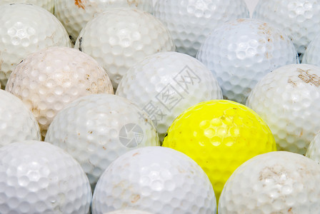 在白球中间的一个黄色高尔夫球图片