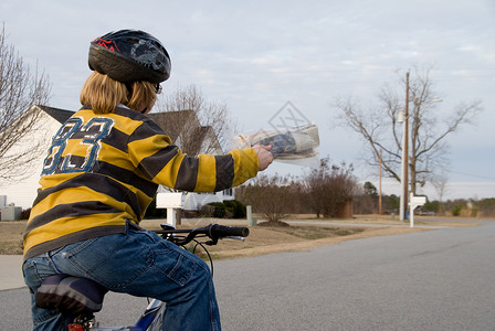 一个骑着自行车送报纸的男孩图片