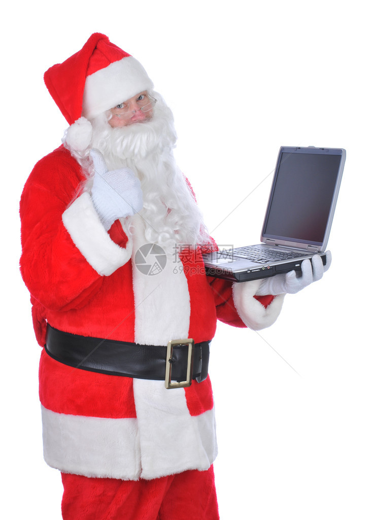 手持笔记本电脑的圣诞老人举起标牌孤图片