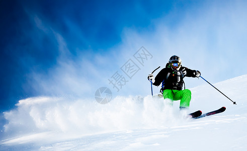 蓝色天空的年轻男自由滑雪员图片