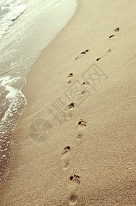 脚印并肩印在沙滩上图片