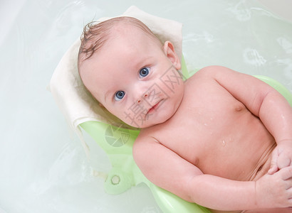 美丽的男婴在沐浴台洗澡图片