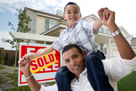 西班牙裔父亲和儿子在他们的新家园前与出售房地产图片