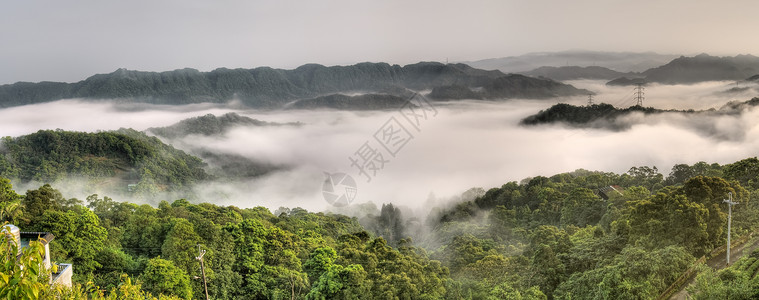 雾和云中电力塔的乡村全景背景图片