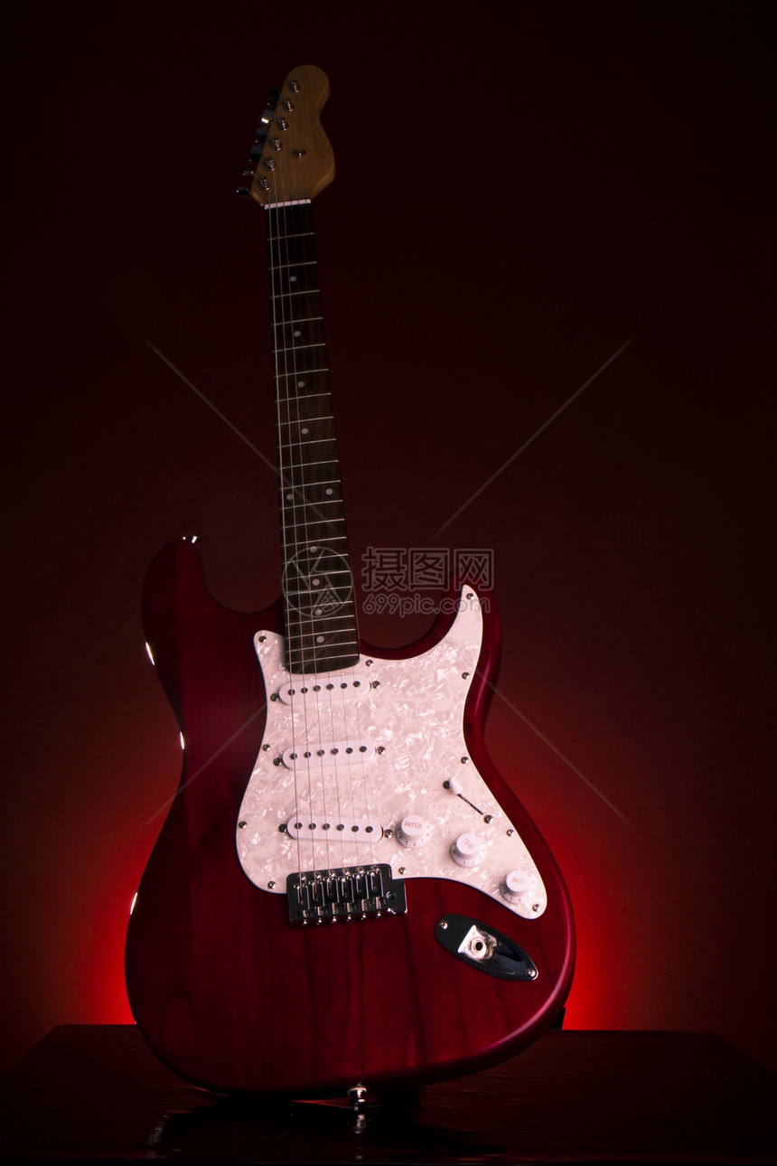 在黑暗的背景的电红色吉他图片