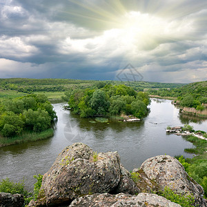 雷雨前有岩石和河流的景观高清图片