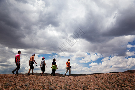 沙漠和暴风云中的一群游客图片