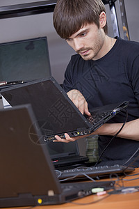 在膝上型电脑上安装新软件的男图片