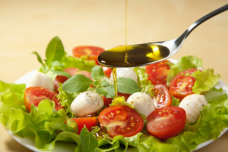 橄榄油倒在沙拉上高清图片