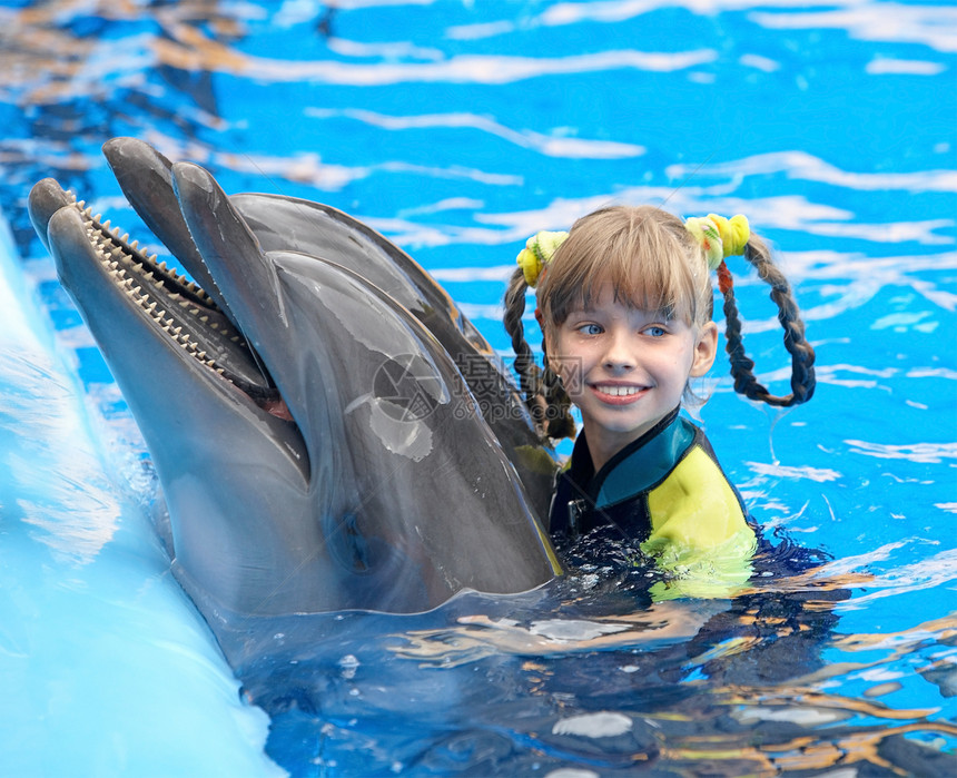 快乐的孩子和蓝色水中的海豚图片