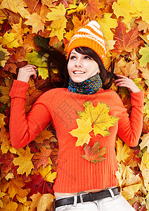 秋天橙色叶子的少妇户外的图片