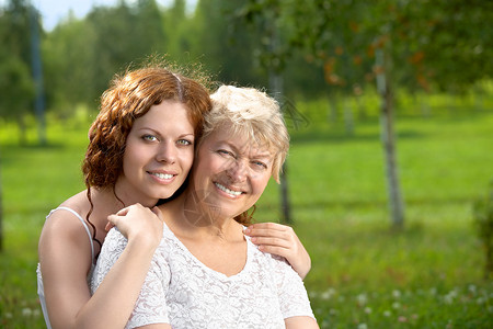 夏日花园里拥抱的女儿和母亲图片