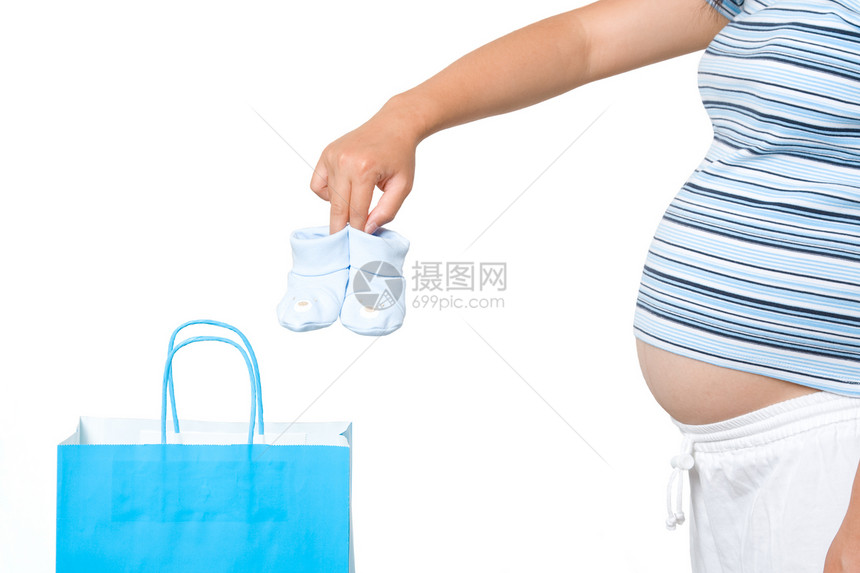 一名孕妇从购物袋中取出婴儿鞋图片