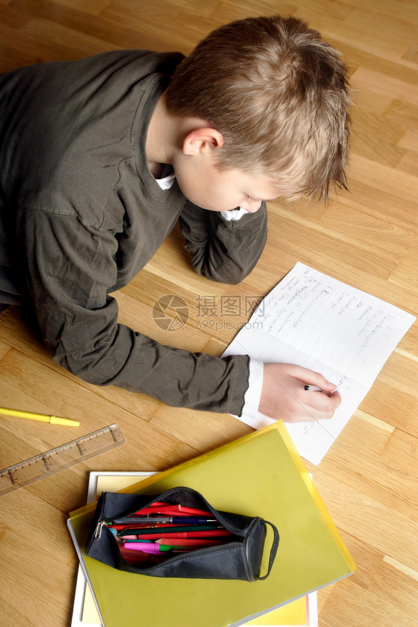 男孩在纸上写字躺在地上图片