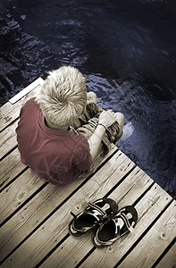 男孩坐在脚桥上独自思考看着图片
