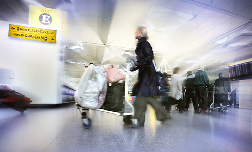 在机场带袋子的妇女图片