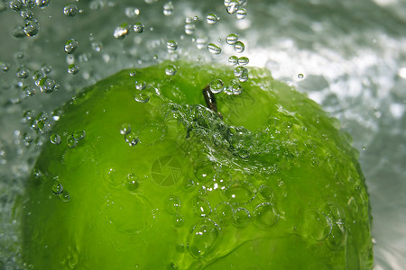 落在一个绿色苹果上的水滴图片