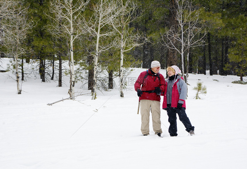 活跃的退休夫妇在雪地里玩耍图片