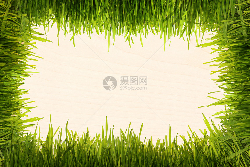 米色木质纹理上的绿草图片