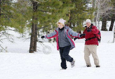 活跃的退休夫妇在雪地里玩耍背景图片