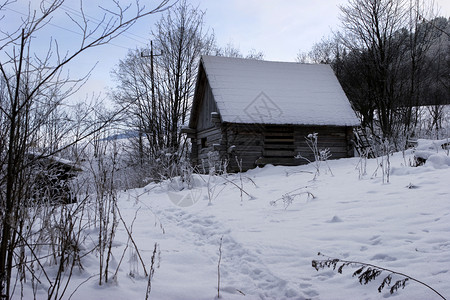 山上覆盖着雪的木屋图片