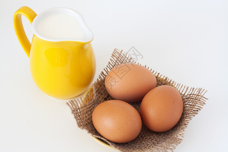 白色背景上的一罐牛奶和鸡蛋图片