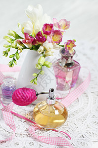 桌上的老式香水瓶和鲜花图片
