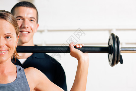 健身房的健身教练用杠铃图片