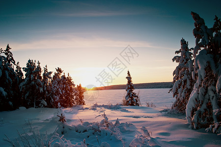 在寒冷的冬季夕阳下冰冻的湖泊和图片