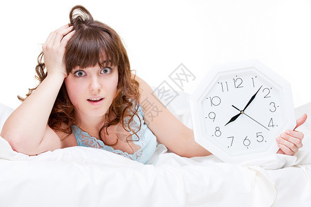 害怕躺在白色床上的时钟的女人图片