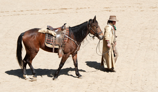 牛仔骑着他的马来到小好莱坞电影集的小镇图片