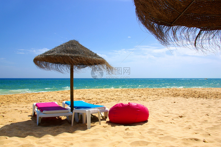 在海滩上看到两个草伞一个枕头和两图片