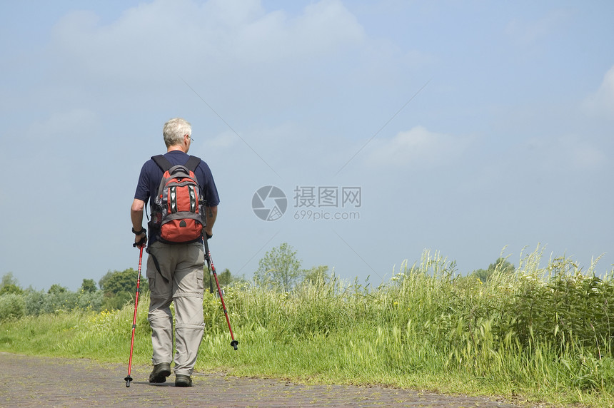 老人在阳光下进行北欧式健走图片