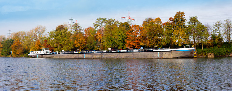 在秋天色的风景中停泊在运河上的德国货船背景图片