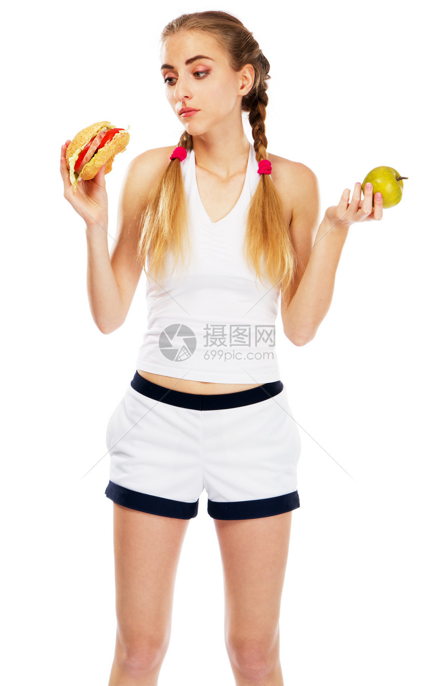 年轻女人拿着汉堡包和苹果图片