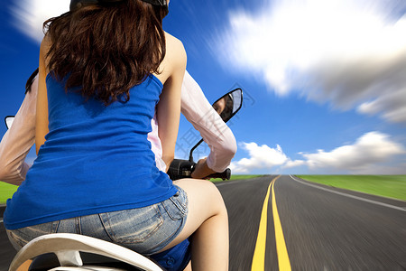 在乡村公路上高速骑摩托车的女童乘坐图片