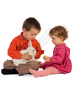 两个儿童男童和女童喂一只可爱的兔子东部图片