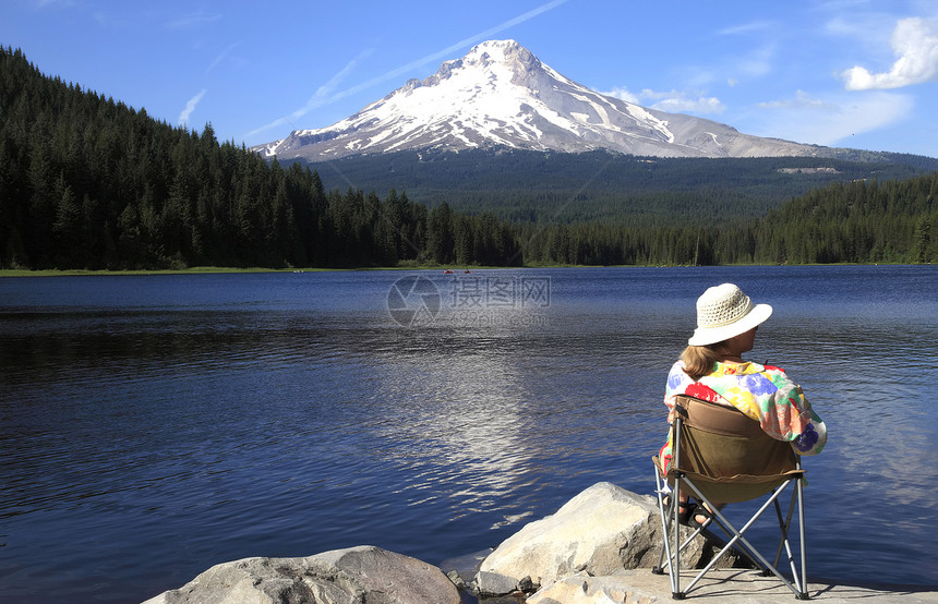 一位坐在湖边的女子享受着周围风图片