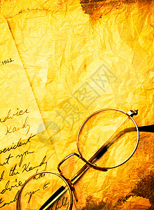 老式纸背景与旧眼镜的特写背景图片