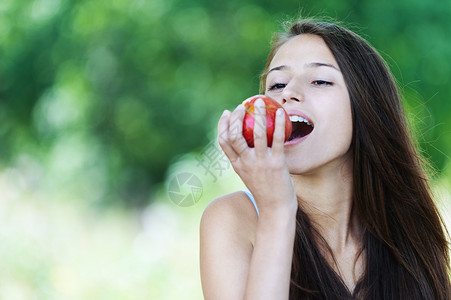 长黑发公园咬红苹果的园区ParkBittingred背景图片