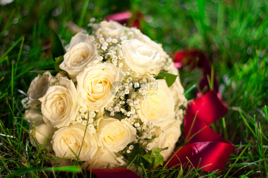 白玫瑰新娘花束躺在草地上图片